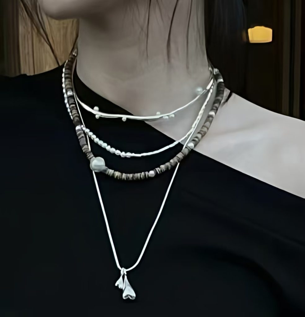 Wear long layered chain necklaces with an asymmetrical neckline for a chic winter outfit.
